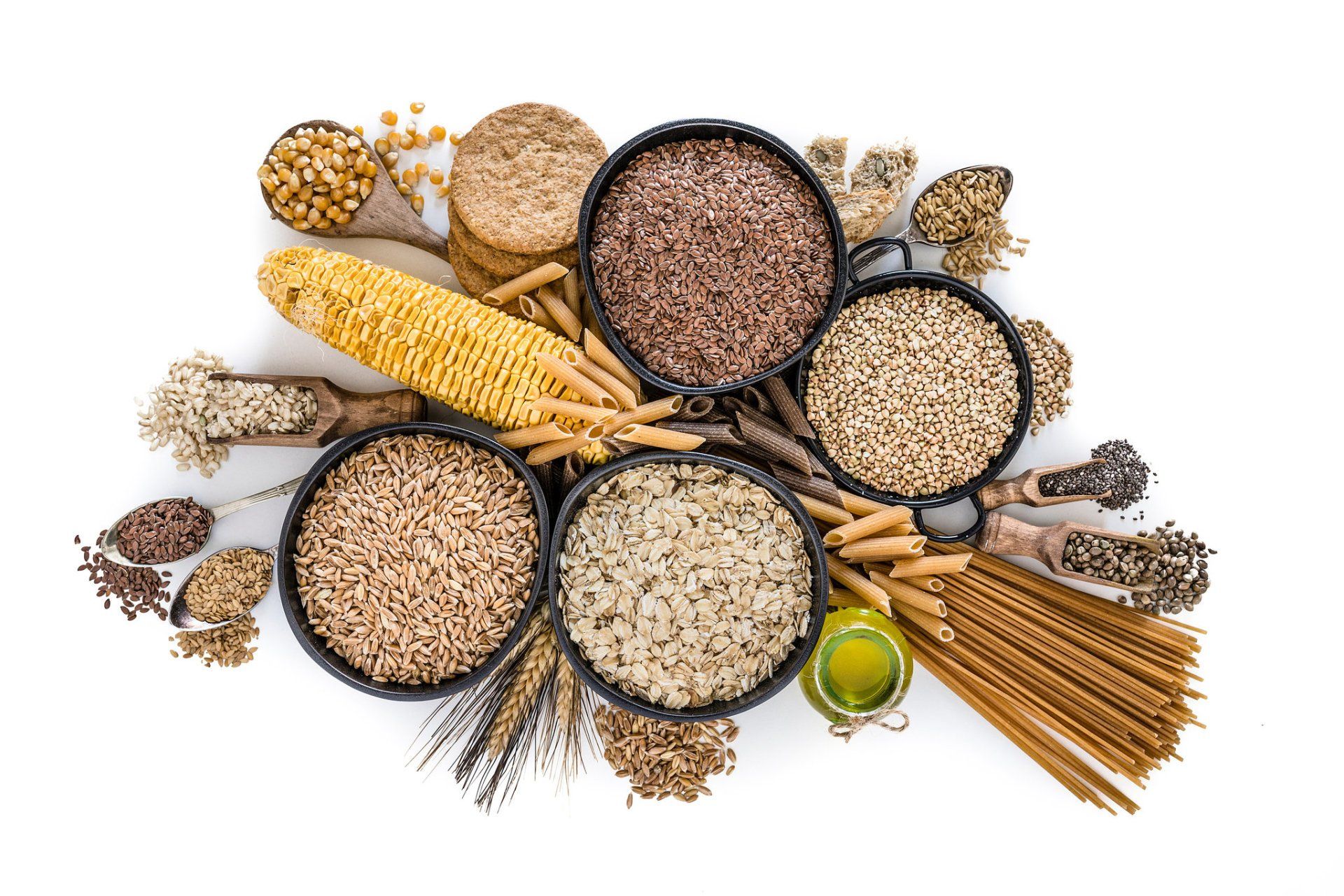 There are many different types of grains in bowls on a white background.