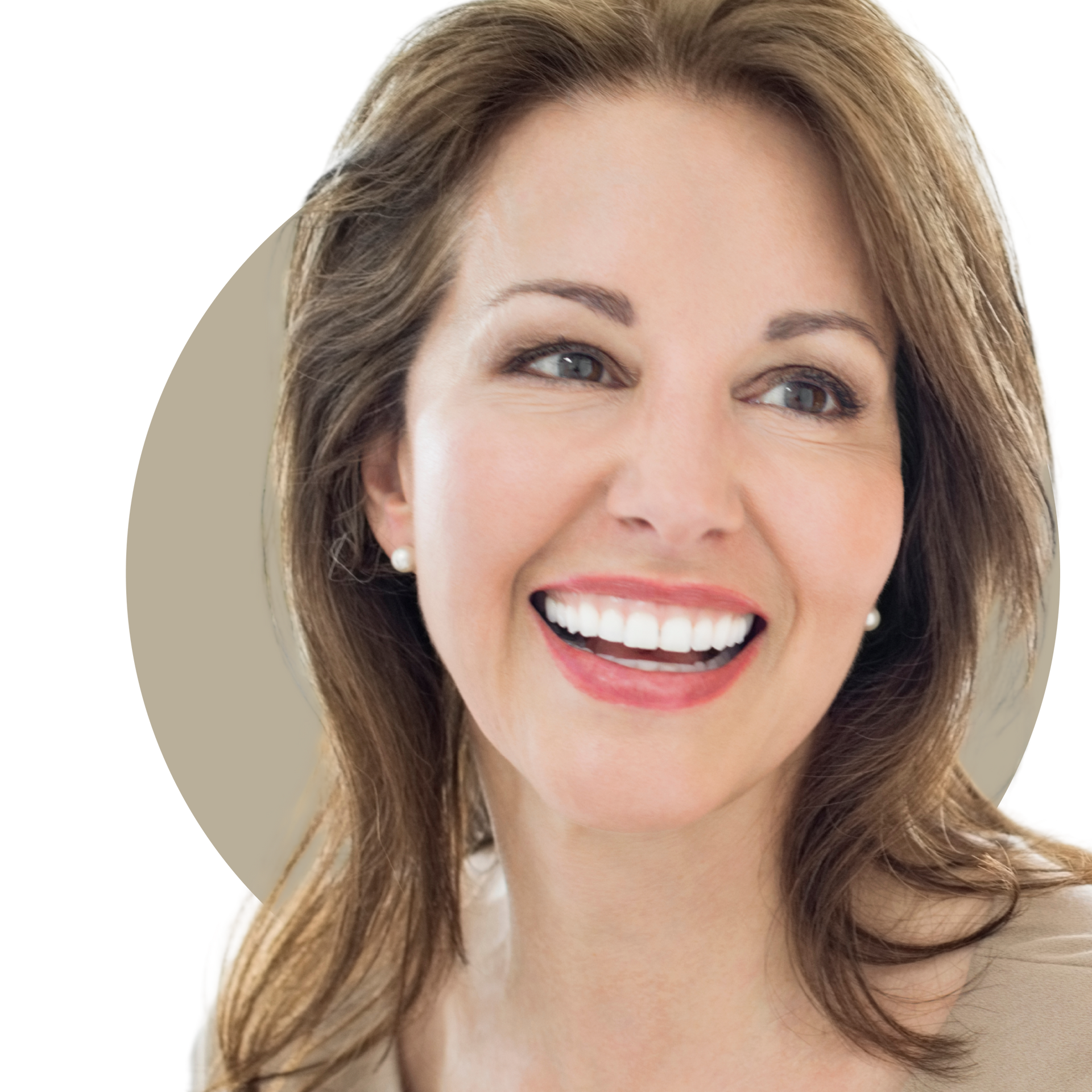 A woman with long curly hair is smiling and touching her face.