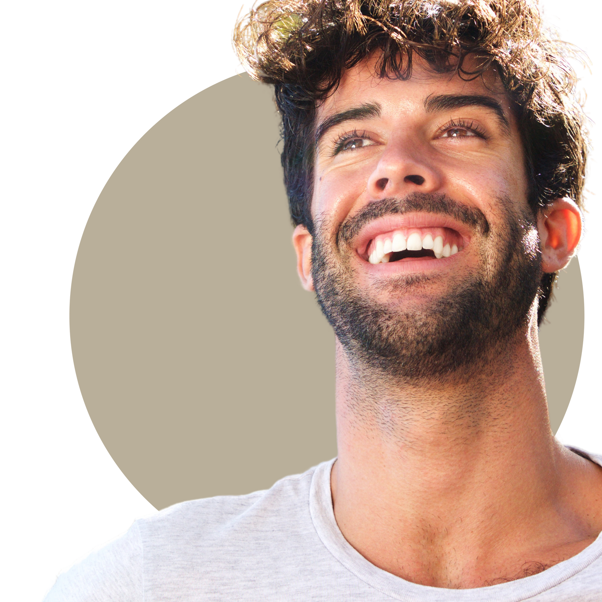 A woman with long curly hair is smiling and touching her face.