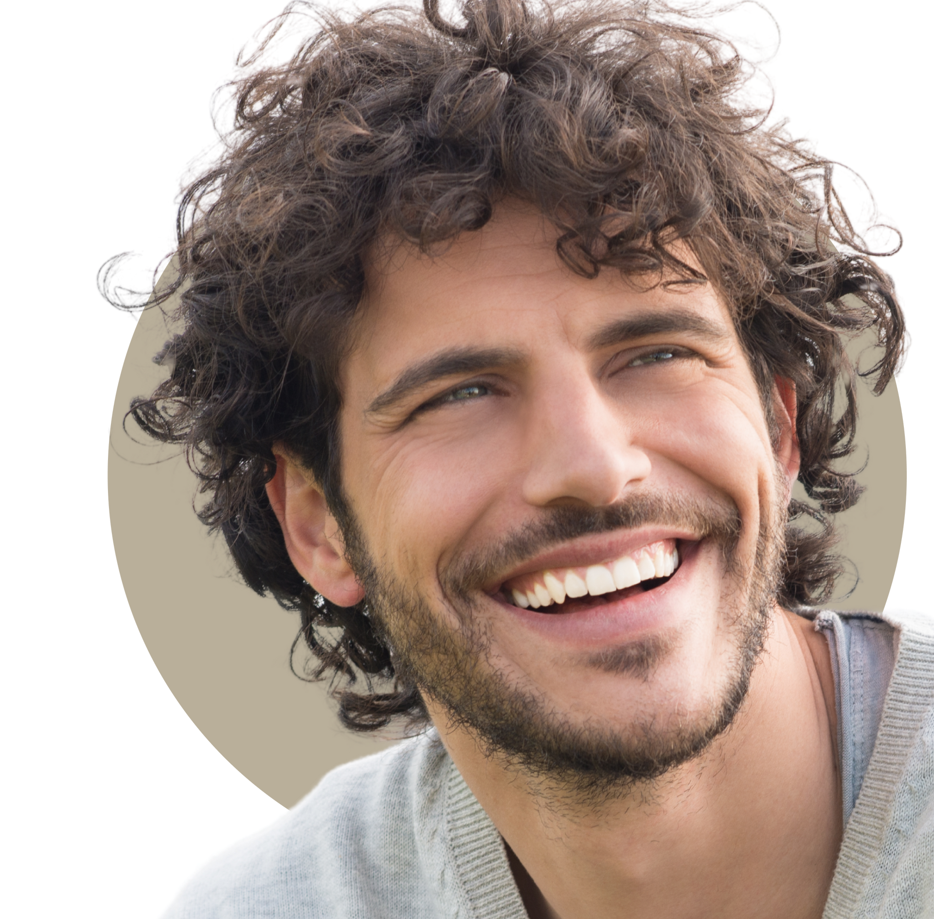 A woman with long curly hair is smiling and touching her face.