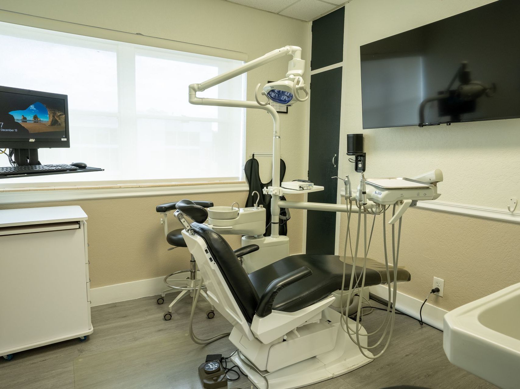 A dental office with a dental chair and a computer