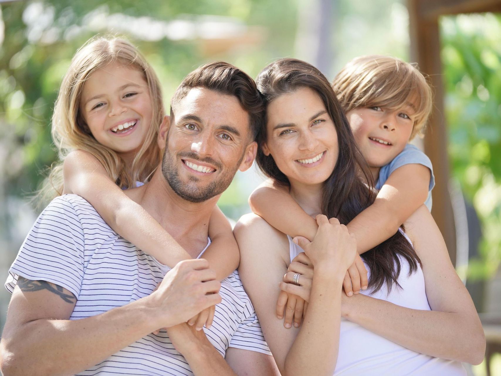 A family is posing for a picture together and smiling for the camera