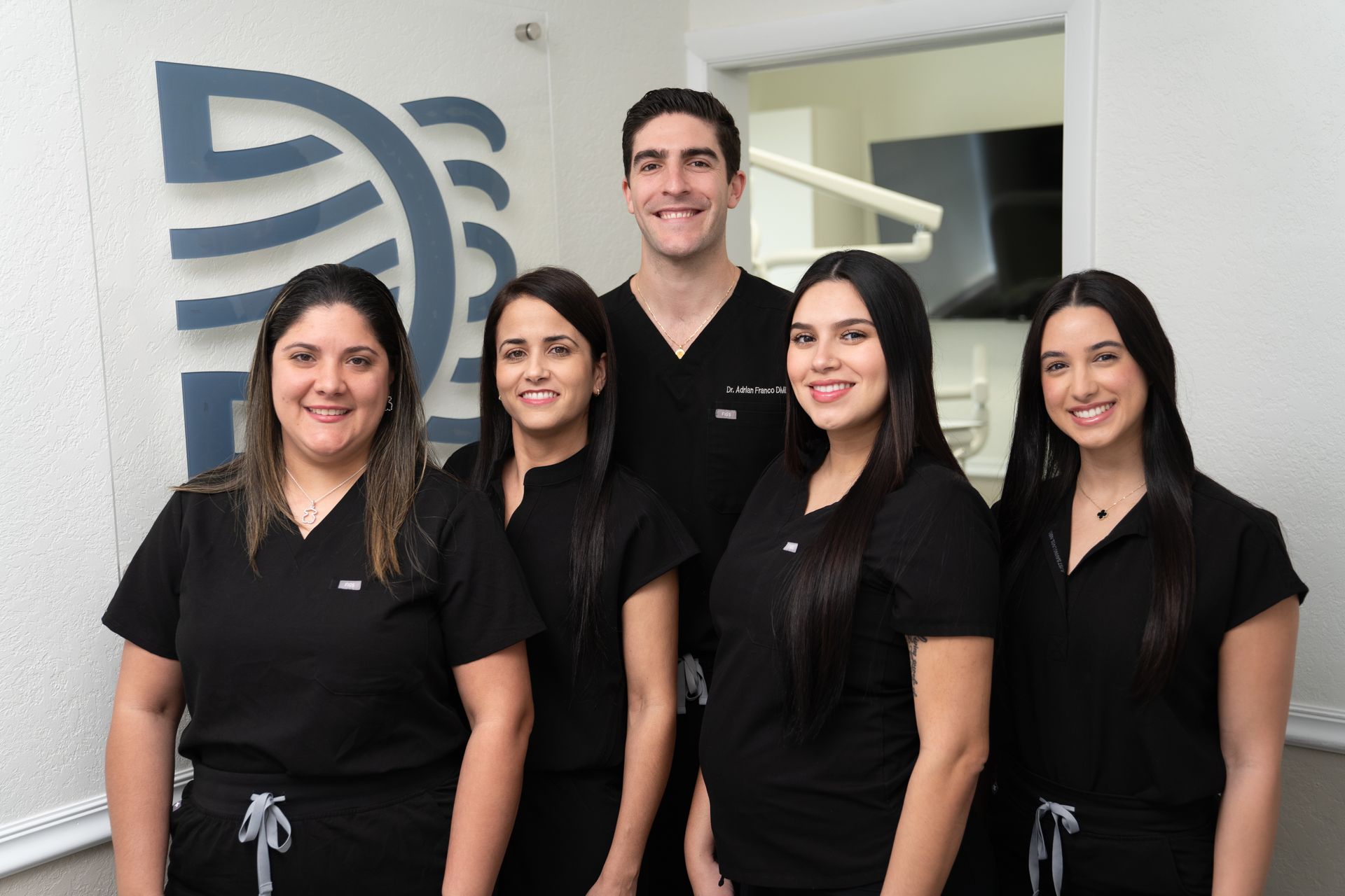 A group of dentists are posing for a picture in a dental office.