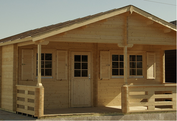 A small wooden house with a porch and shutters