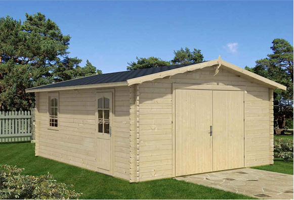 A wooden garage with a black roof is sitting on top of a lush green lawn.