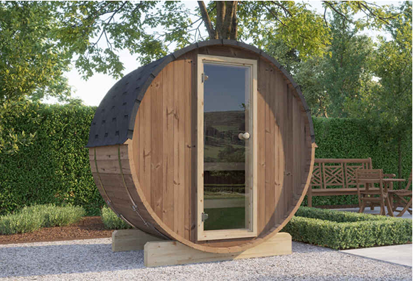 A wooden barrel with a glass door is in a garden.