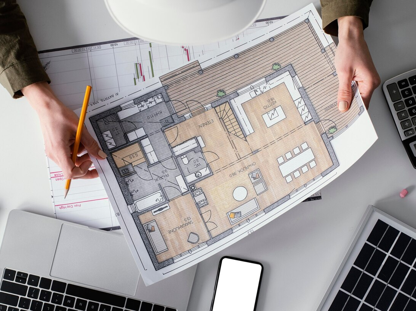 A person is holding a floor plan of a house.