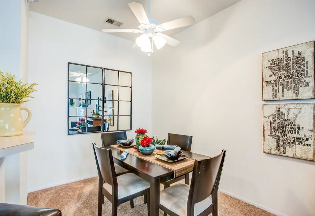 Dining room with a dark wood table and chairs, a large mirror, and abstract artwork on the wall.