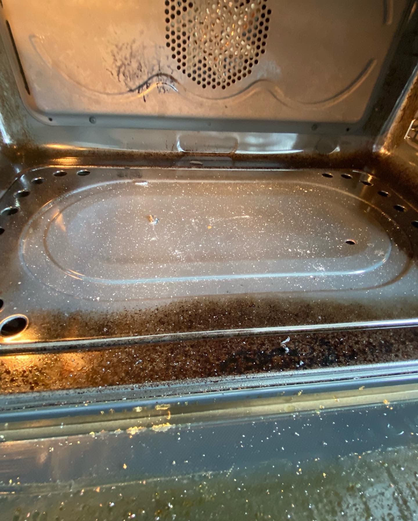 The inside of a microwave oven is dirty and needs to be cleaned.