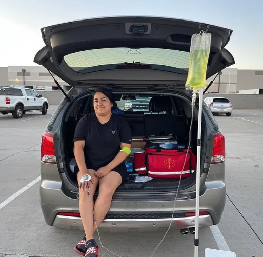 A woman is sitting in the back of a car