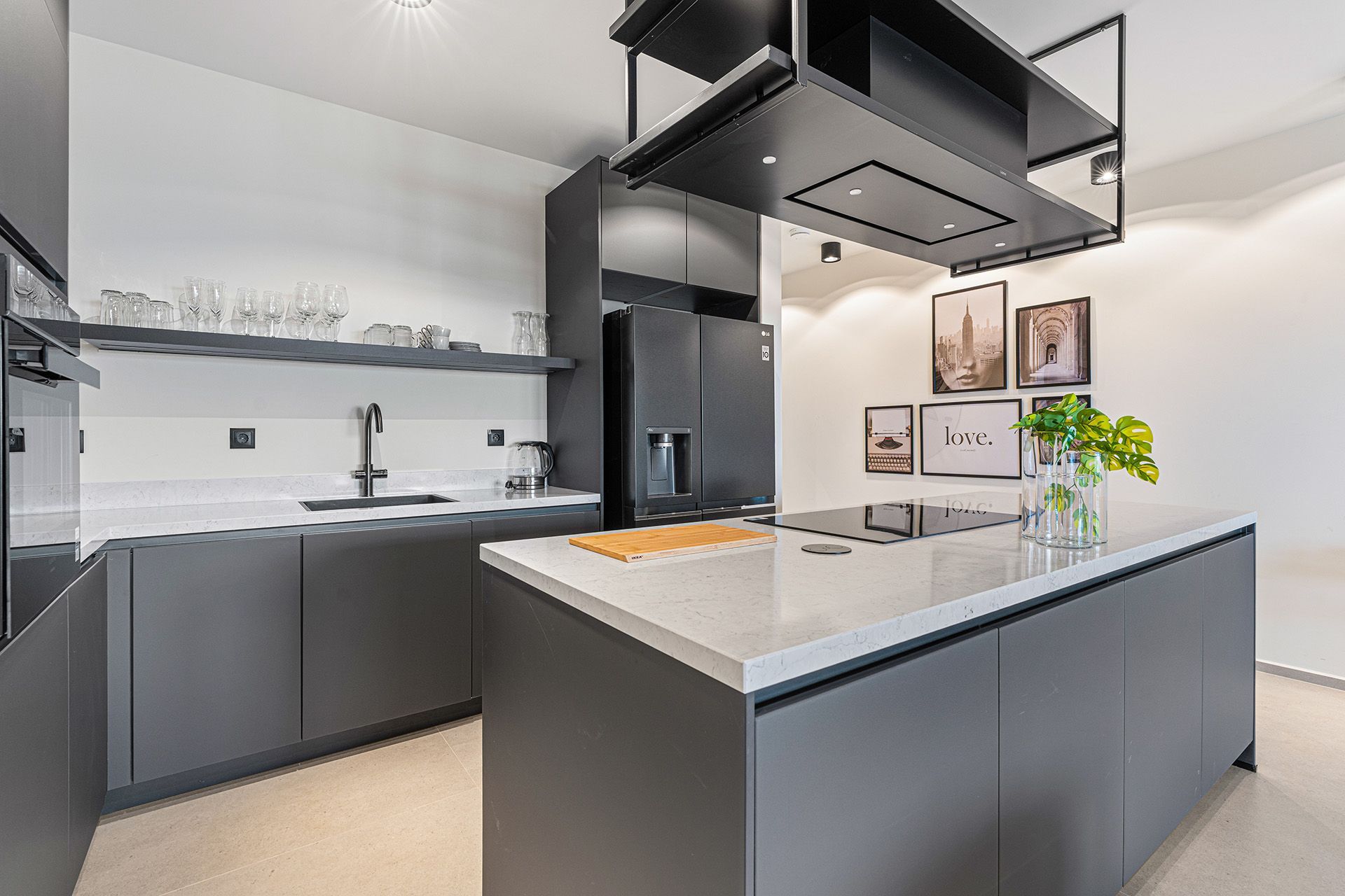 Modern gray kitchen with island, range hood, and white countertops.