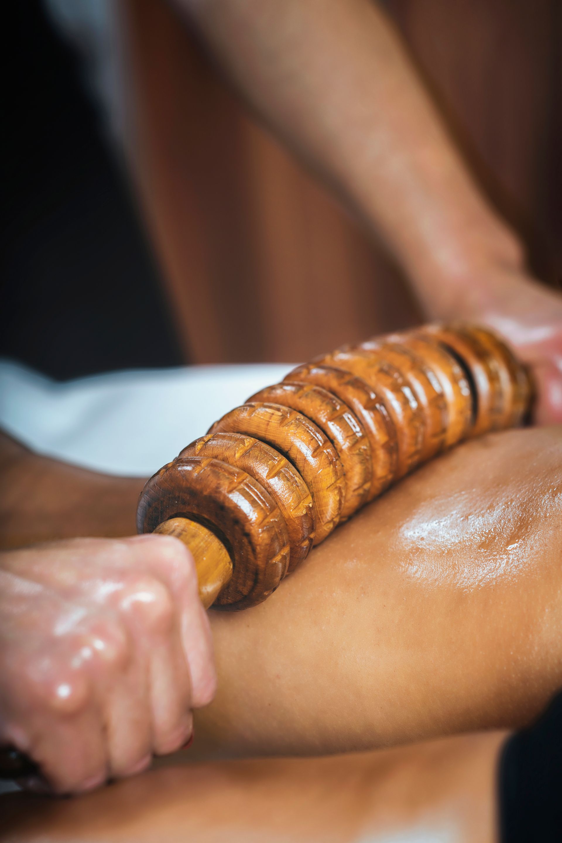 a woman is getting a wooden massage on her body.