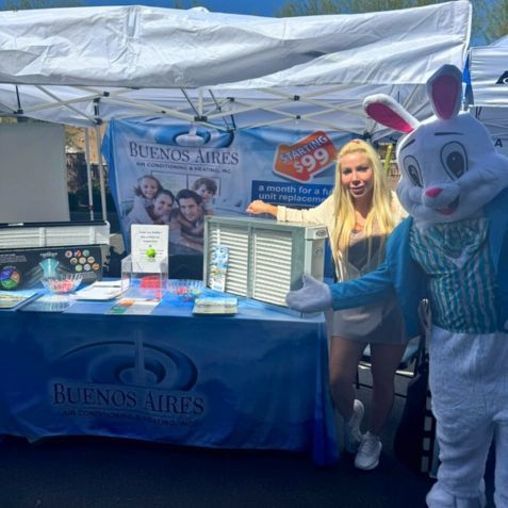 Woman and Easter Bunny stand at a Buenos Aires booth with promotional materials outdoors.