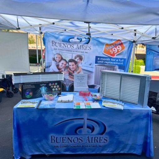 Buenos Aires Air Conditioning & Heating Inc. booth; blue tablecloth, air filters displayed, tent.