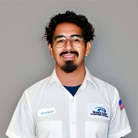 Man with glasses, wearing a white uniform shirt with a company logo, smiling.