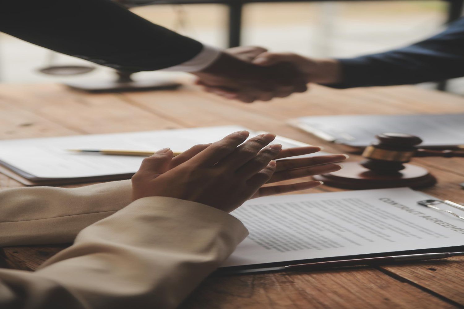 An elderly couple examines paperwork together at a table, one pointing while the other types on a laptop.