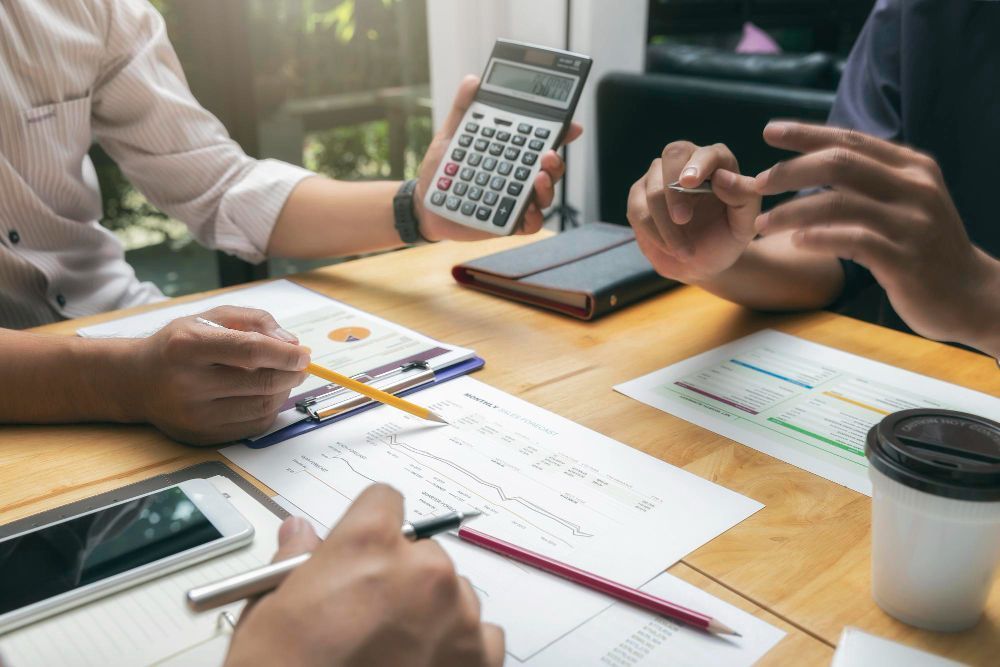 An older couple reviews documents with a financial advisor at a table.