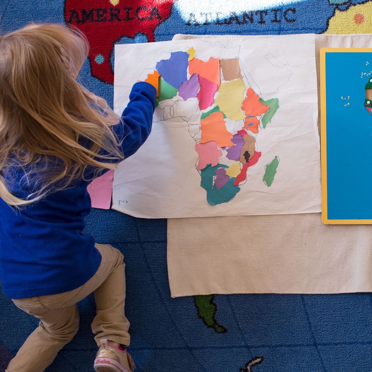 Montessori child is working with geography materials