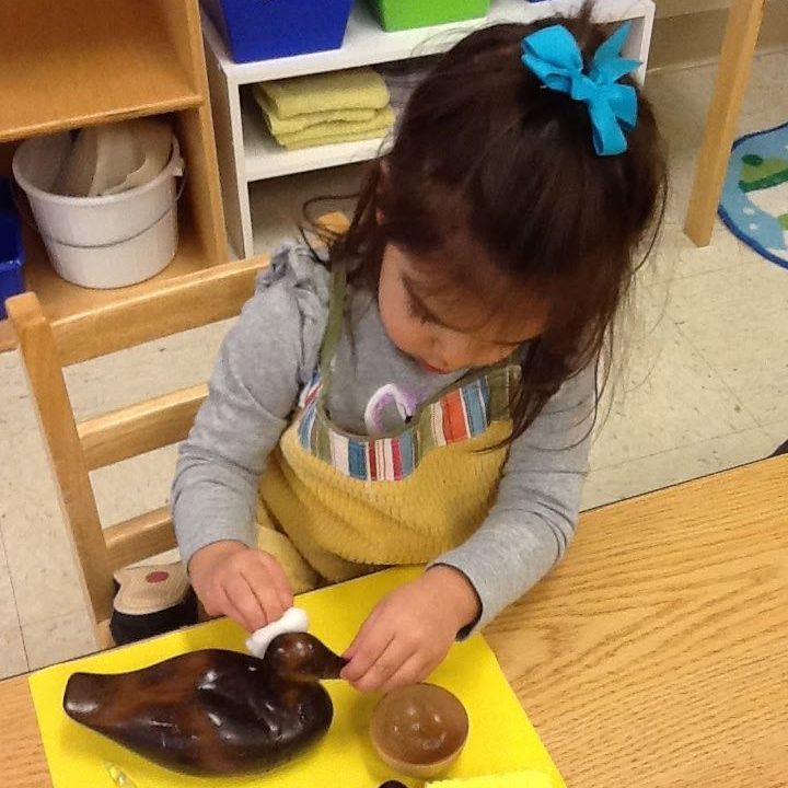 Montessori child cleaning a wooden duck