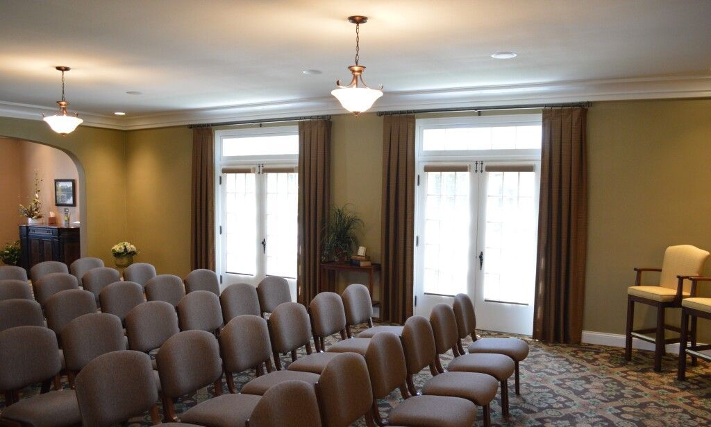 A large room with rows of chairs and windows