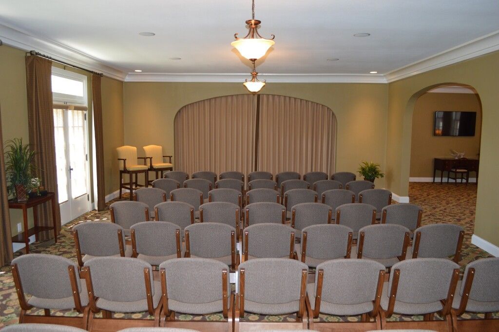 Rows of chairs in a room with a chandelier hanging from the ceiling