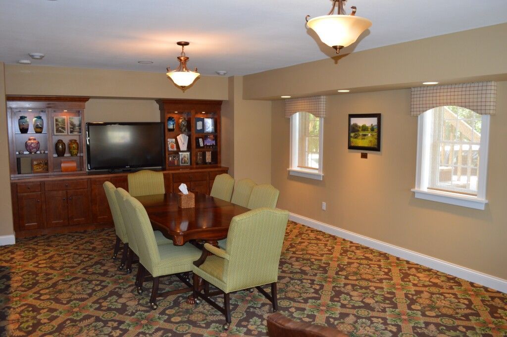 A living room with a table and chairs and a television.