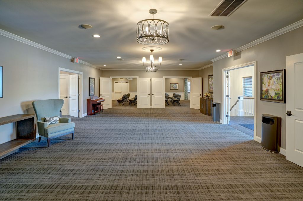 A large room with a couch , chairs , and a chandelier.
