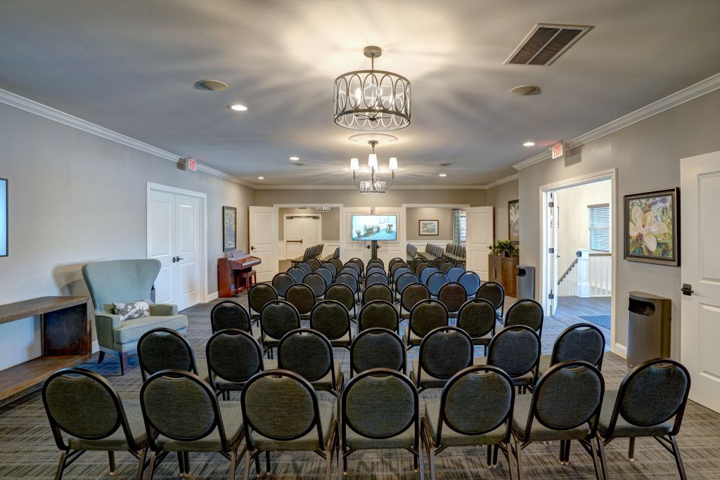 A large room with rows of chairs and a chandelier.