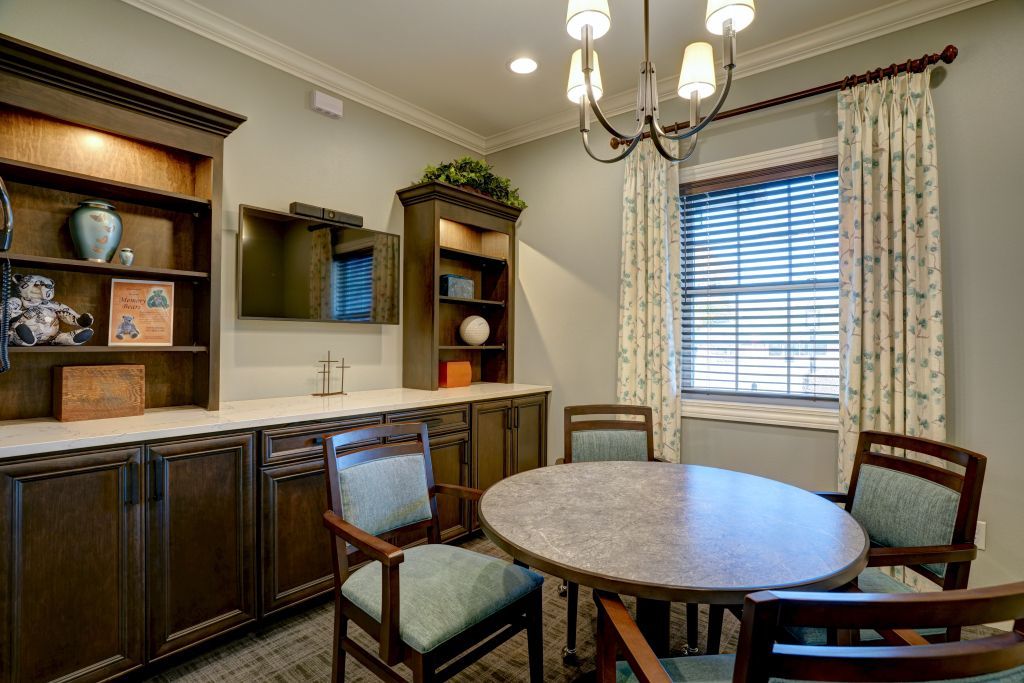 A dining room with a round table and chairs and a chandelier.