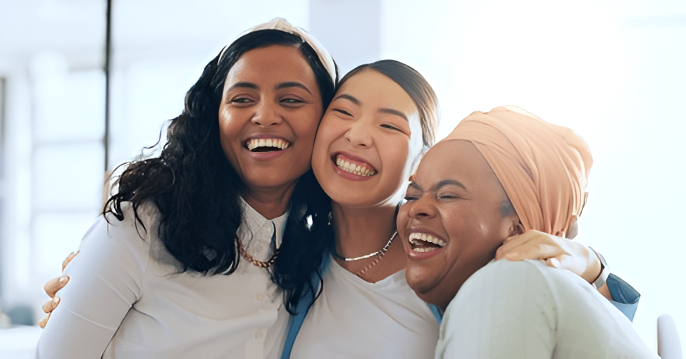 A woman is holding the hand of an elderly man while sitting in a chair.