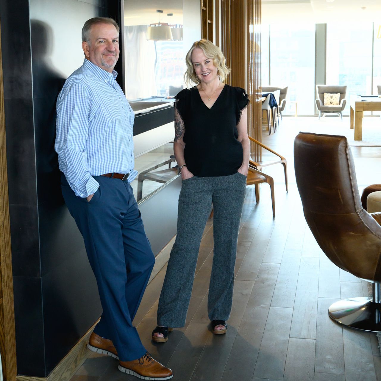 A woman is typing on a laptop while another woman is signing a document.