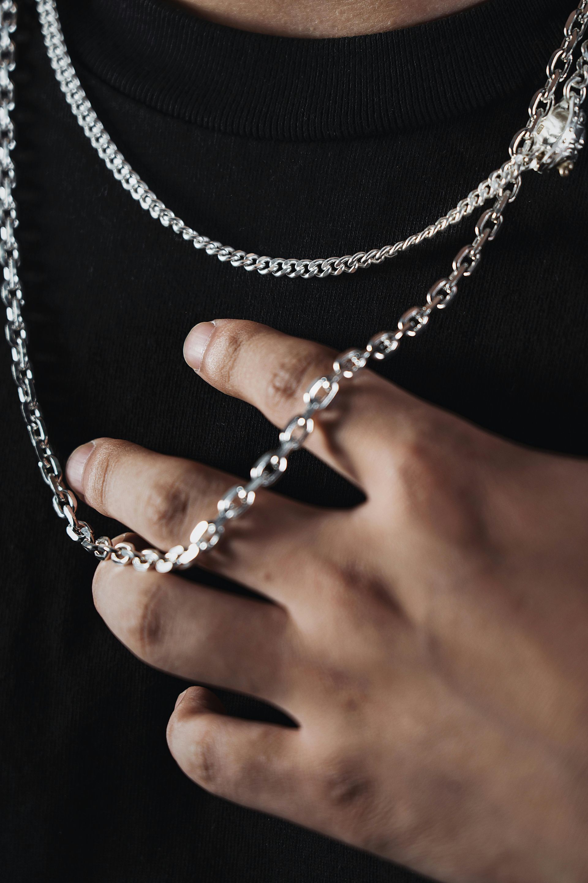 Woman in straw hat smiles, holding wine glass near a lake.