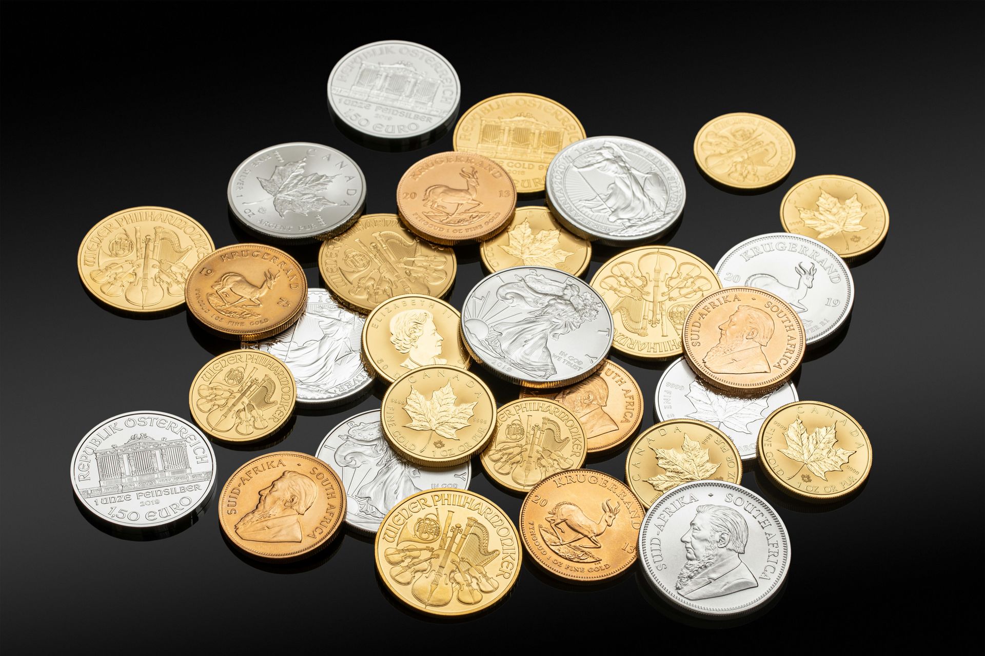 A collection of gold and silver coins scattered on a black background.