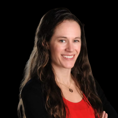 Woman with long brown hair smiles, wearing a red shirt and black cardigan against a black background.