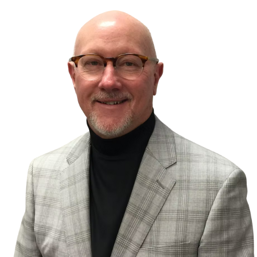 Man with glasses, bald head, and goatee, wearing a plaid jacket and black turtleneck.