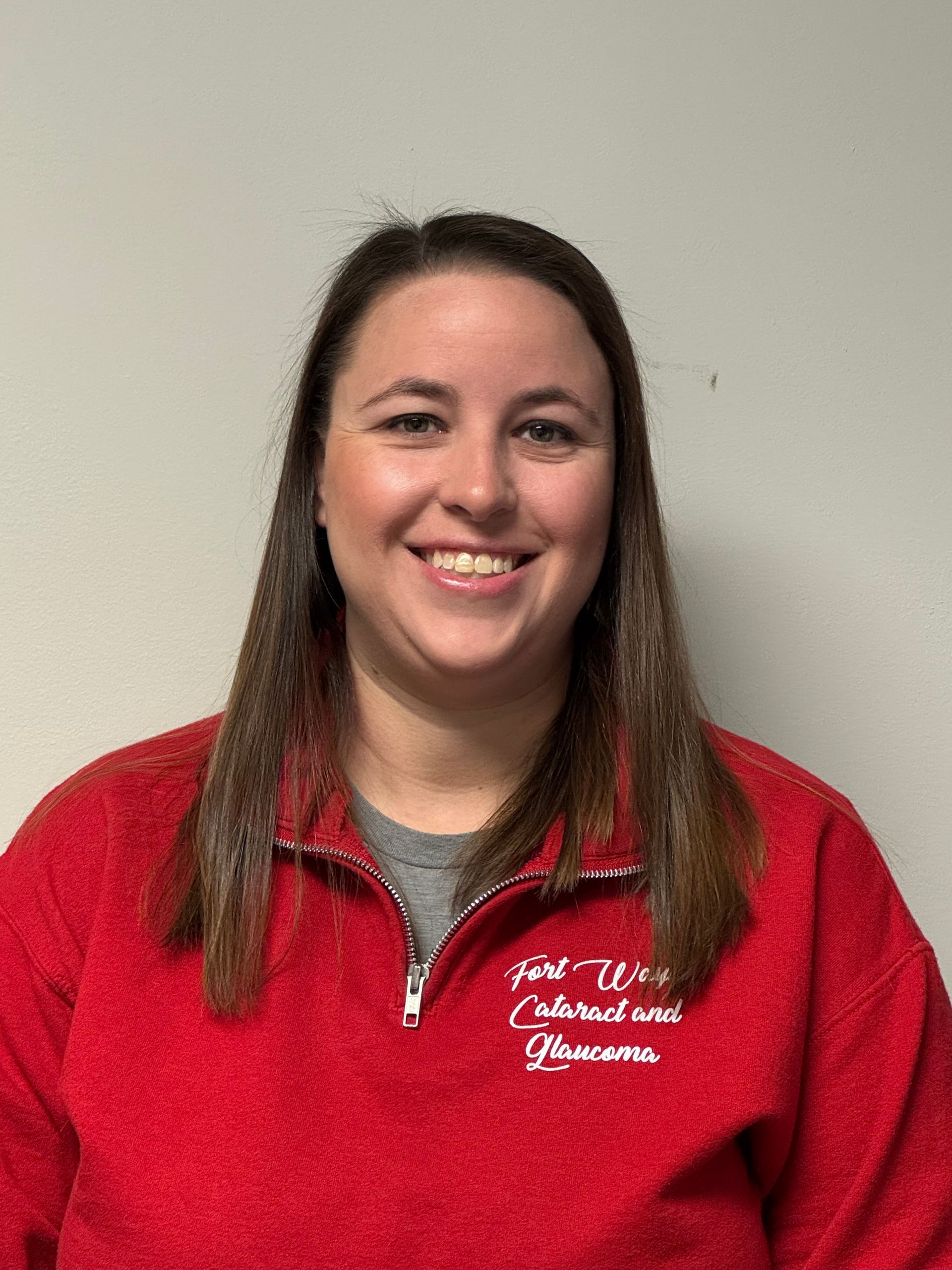 Woman smiling, wearing a denim jacket, looking directly at the camera.