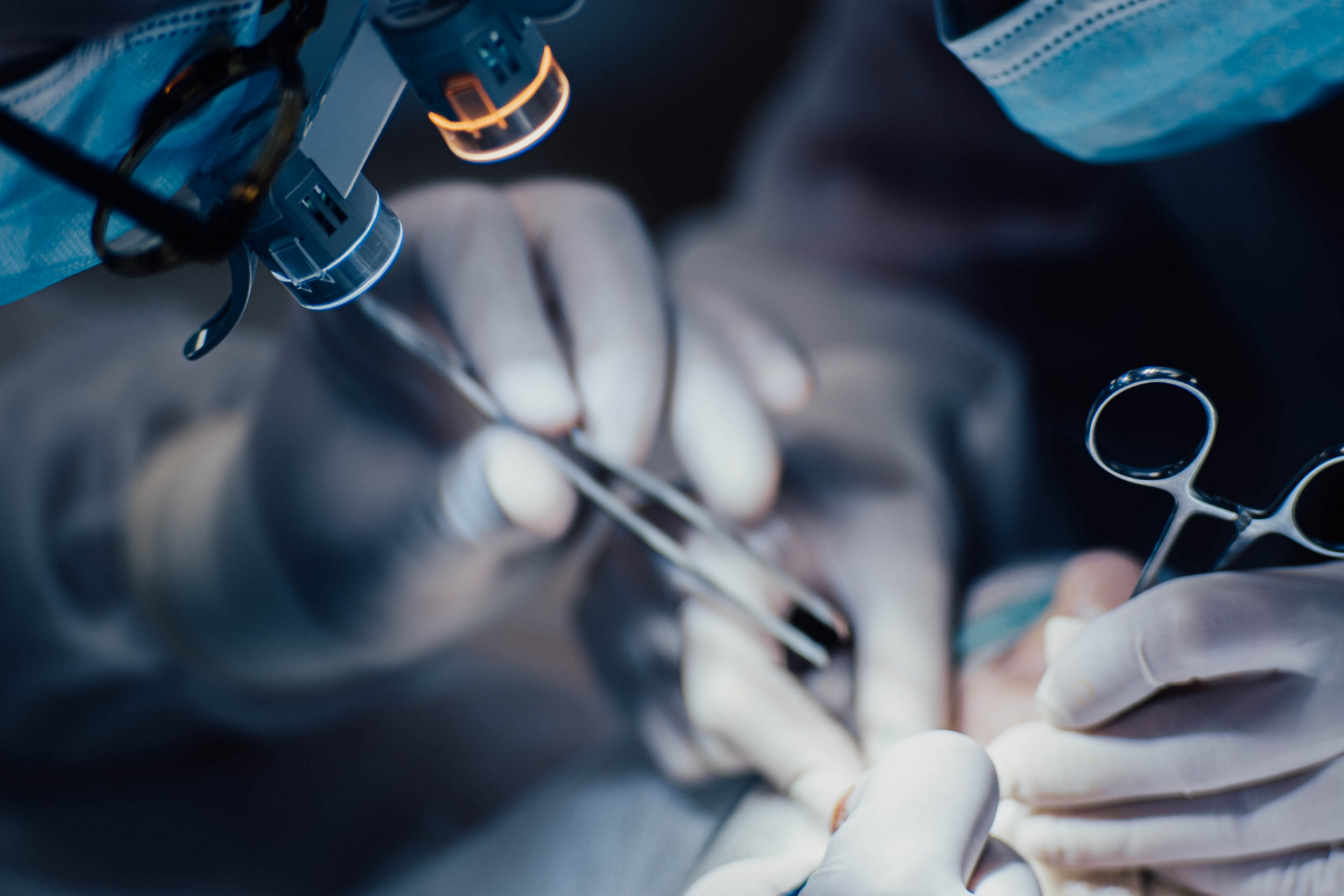 A surgeon is examining a patient 's eye under a microscope.