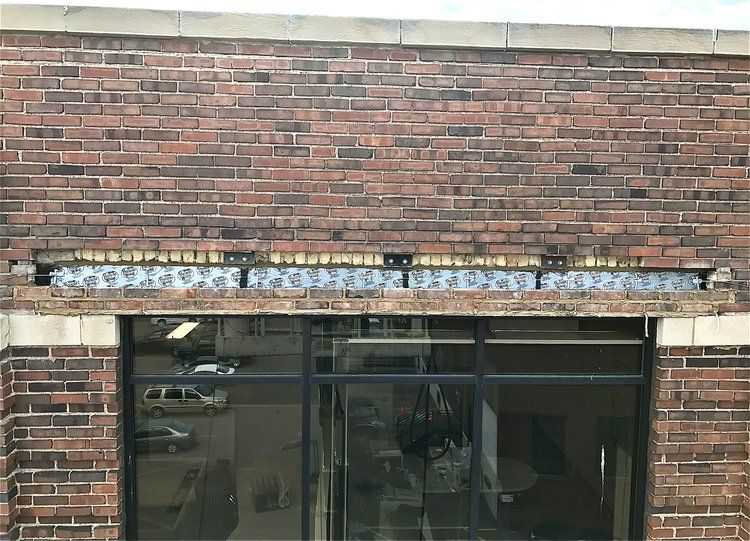 A brick building with a large window and a brick beam above it