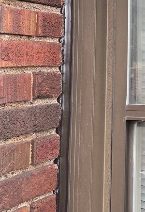 A close up of a brick wall next to a window.