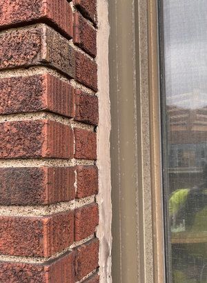 A close up of a brick wall next to a window.