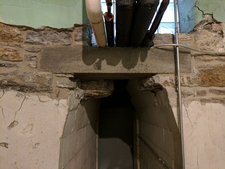 A hole in a wall with pipes coming out of it