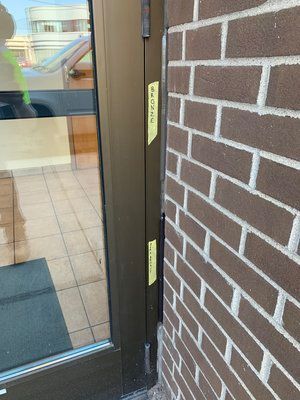 A close up of a brick wall with a door in the background.