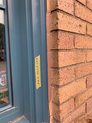 A brick wall with a window and a sticker on it.