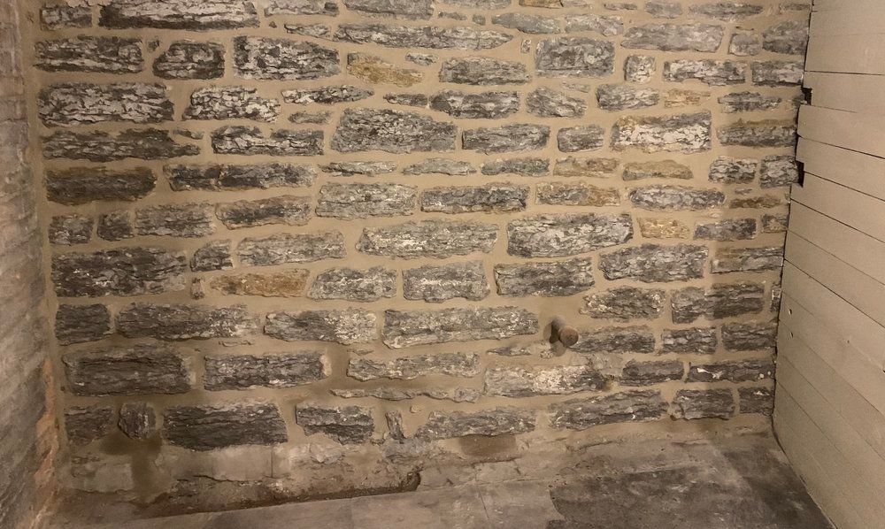 There is a brick wall in the corner of the room.