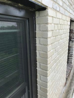 A close up of a brick wall with a window on it.