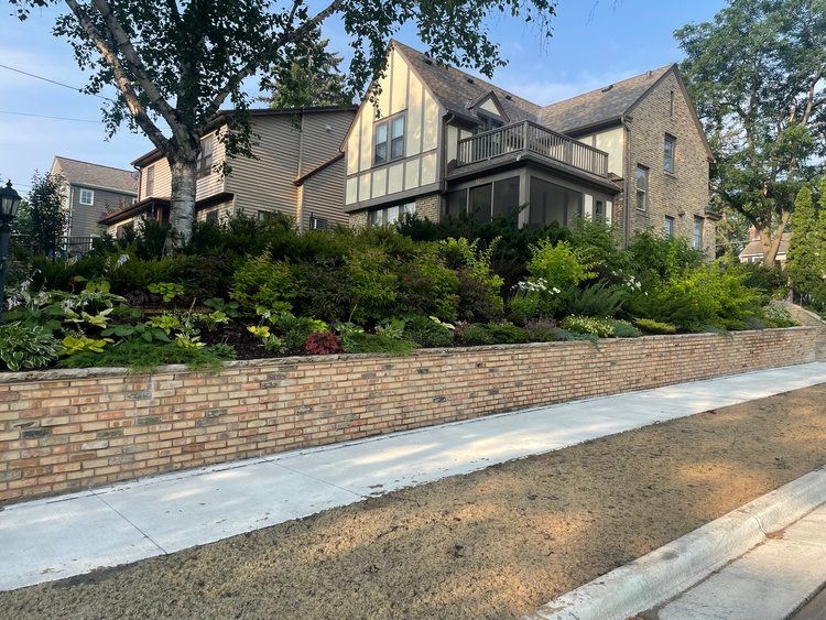 A large house with a brick wall in front of it.