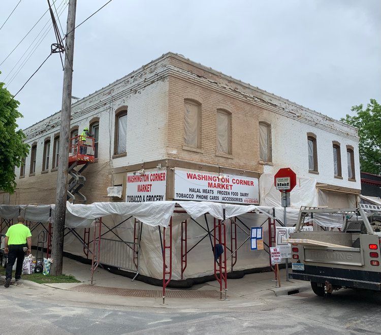 A white building with a sign on the side that says washington corner market