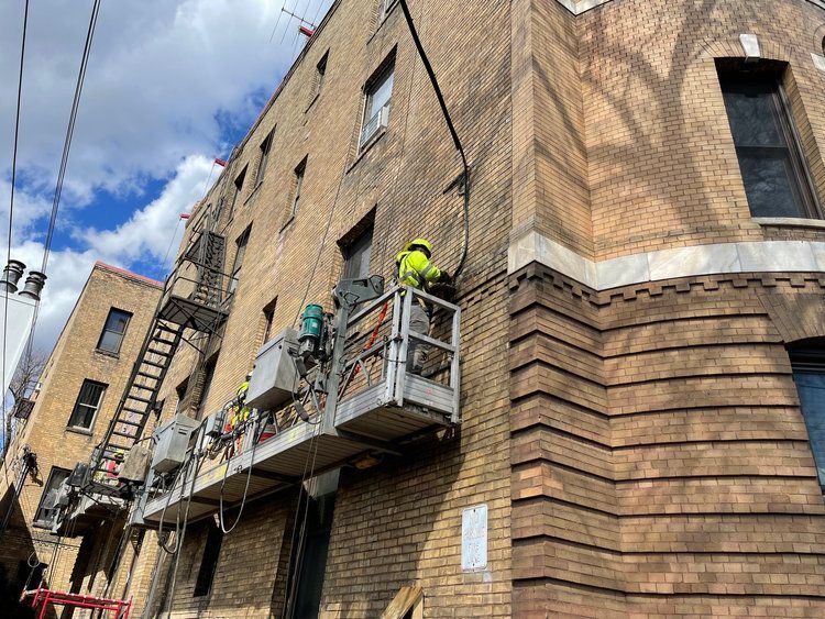 A man is standing on a scaffolding on the side of a building.