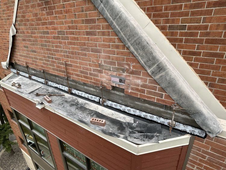 A brick building with a roof that is being repaired.