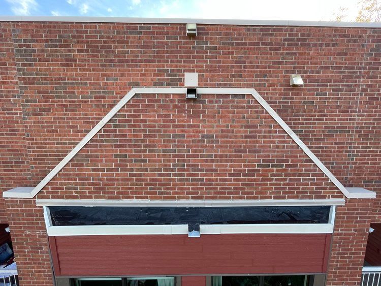 An aerial view of a brick building with a white awning over the door.